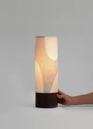 This lamp is part of our LUMA Collection which explores the dynamic balance between positive and negative spaces. This handcrafted table lamp provides a warm and soft ambient light bringing to your interior a unique piece. Made of a minimalist black walnut lamp base and a unique printed linen shade. The hefty and simple design of the base shows off the natural character of the wood hand finished with Danish Oil for a classic low-luster look.